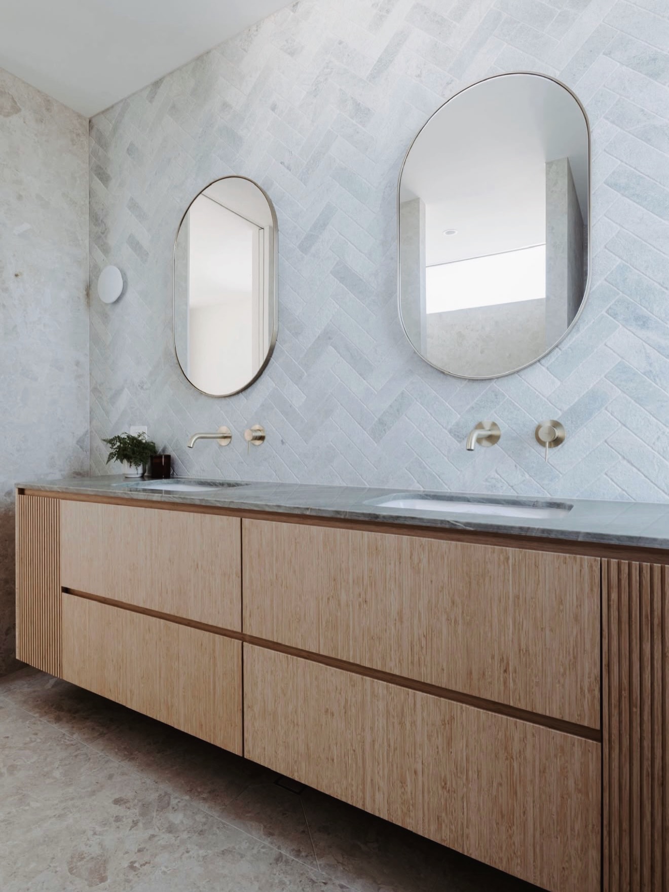 Bathroom with bamboo vanity and rounded mirrors