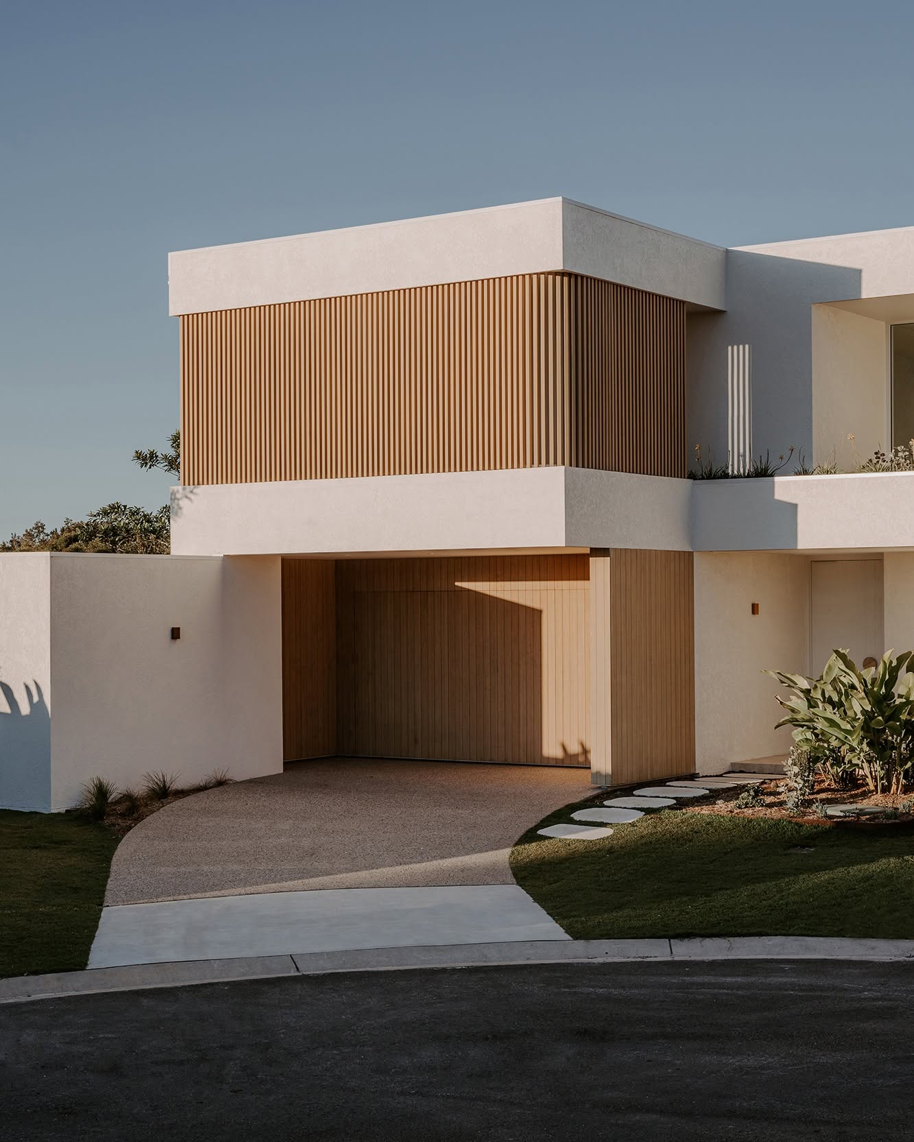 Harvest Moon residence, with timber battens and sculpted white masonry
